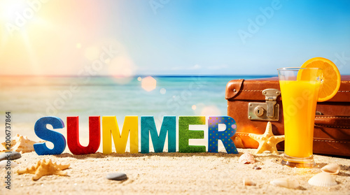 Colorful summer sign with juice suitcase on sunny beach