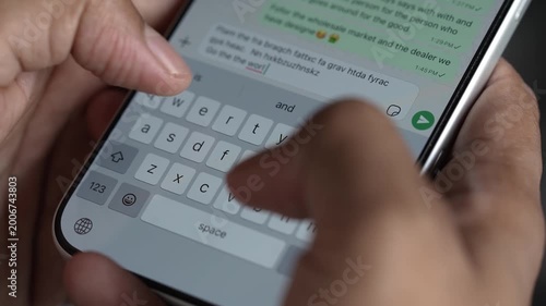 Close-up macro shot of anonymous male hands typing and chatting on a smartphone, fingers tapping a touchscreen keyboard while sending text messages in a modern digital environment. Unrecognizable pers