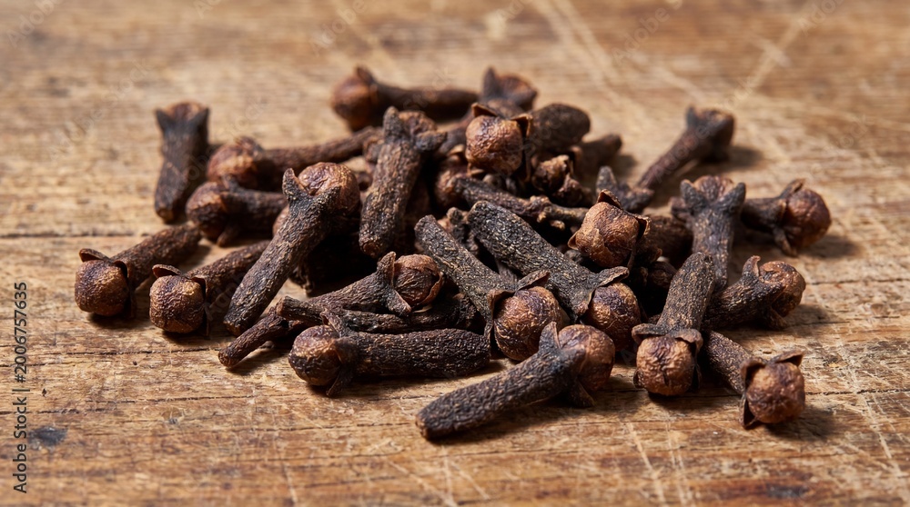 Obraz premium Pile of whole cloves on a wooden surface