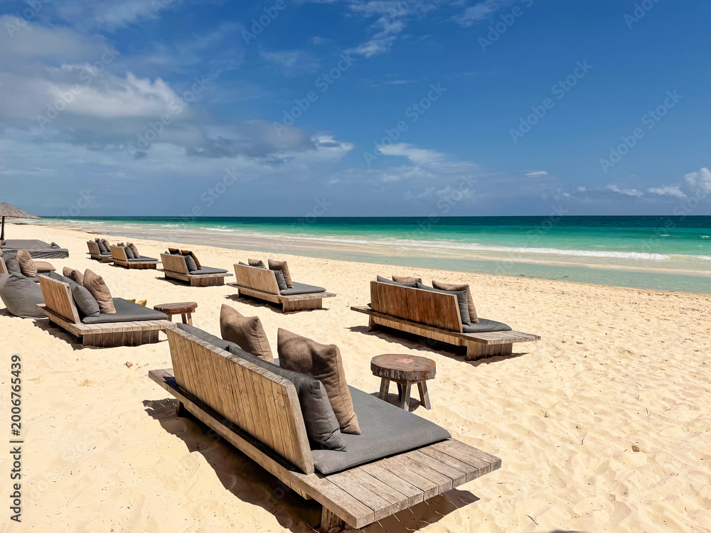Fototapeta premium Many daybeds near sea at tropical resort
