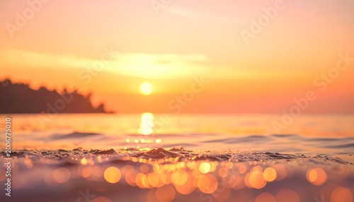 Golden hour sunset over calm ocean with bokeh waves and orange sky, serene beach landscape at dusk
