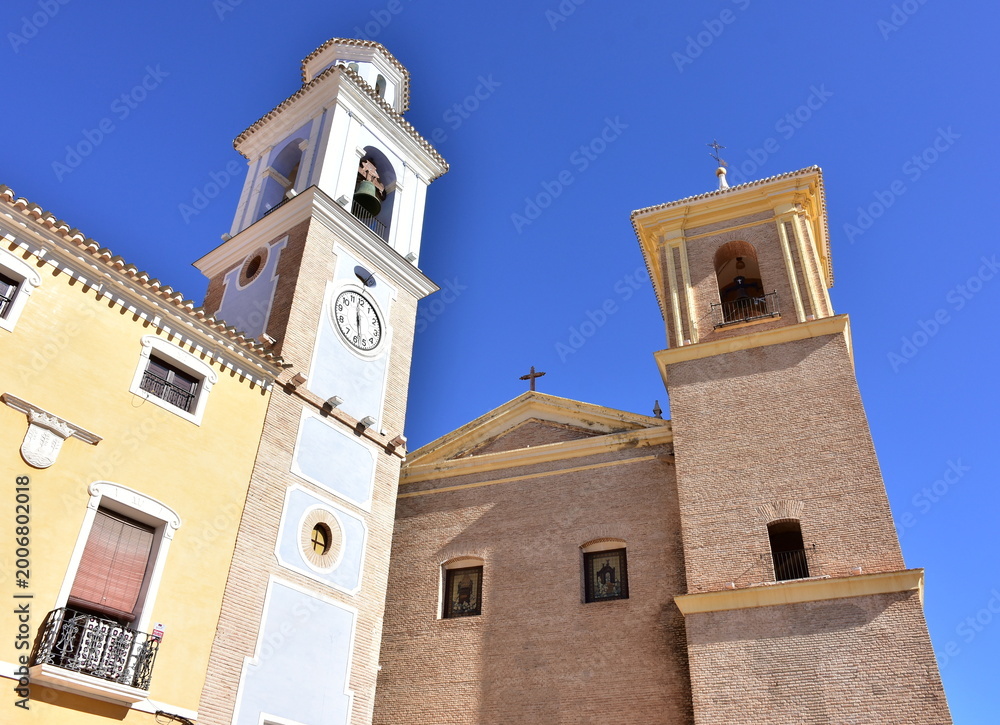 Seinätarra bell tower Reloj and church Saint Miguel on square in village Mula in Spain
