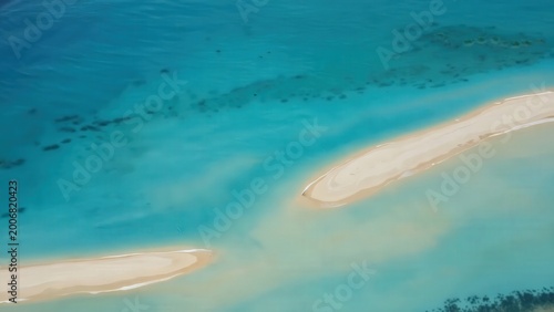 Aerial view of tropical sandbars surrounded by turquoise water, showcasing the gradual transition of colors and textures in a serene coastal landscape