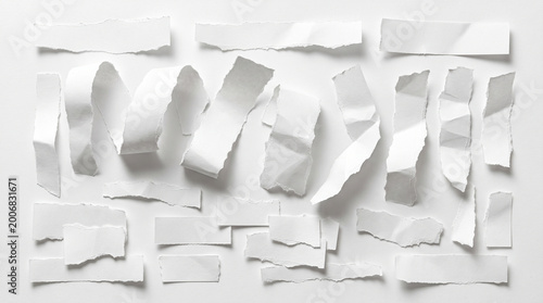 Scattered torn white paper pieces and strips on a white background abstract background paper scraps design element paper cut textured background flat lay recycled paper office supplies