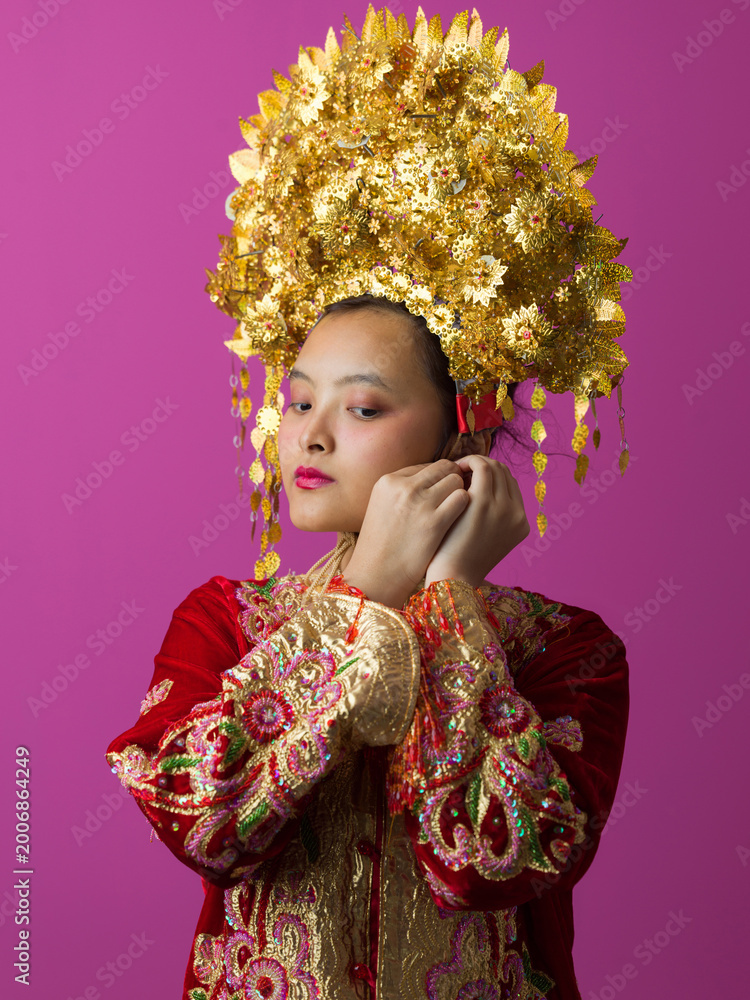 Obraz premium Traditional Gold Bridal Headdress and Embroidered Red Costume Portrait of Young Asian Bride