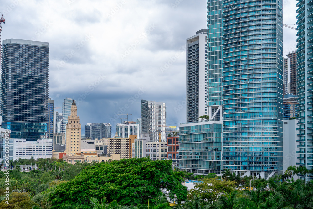Fototapeta premium Freedom Tower and modern glass buildings in downtown Miami. Detailed architectural view of the historic Freedom Tower surrounded by modern high-rise apartments in Miami.