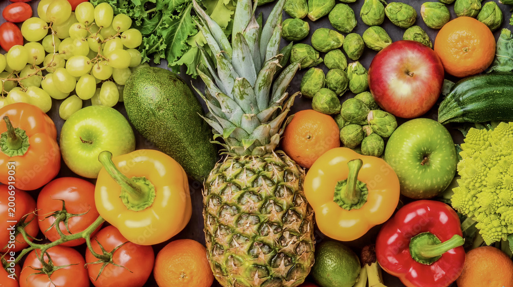 Fototapeta premium Vibrant flat-lay of fresh fruits and vegetables, including pineapple, peppers, and grapes. High-quality food photography with rich colors. Ideal for health, wellness, and culinary themes.