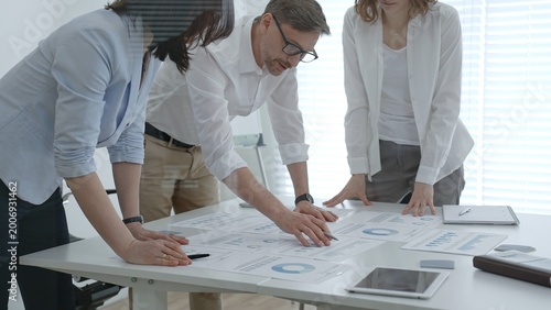 Foto Business professionals collaborating around a modern office table, reviewing cha