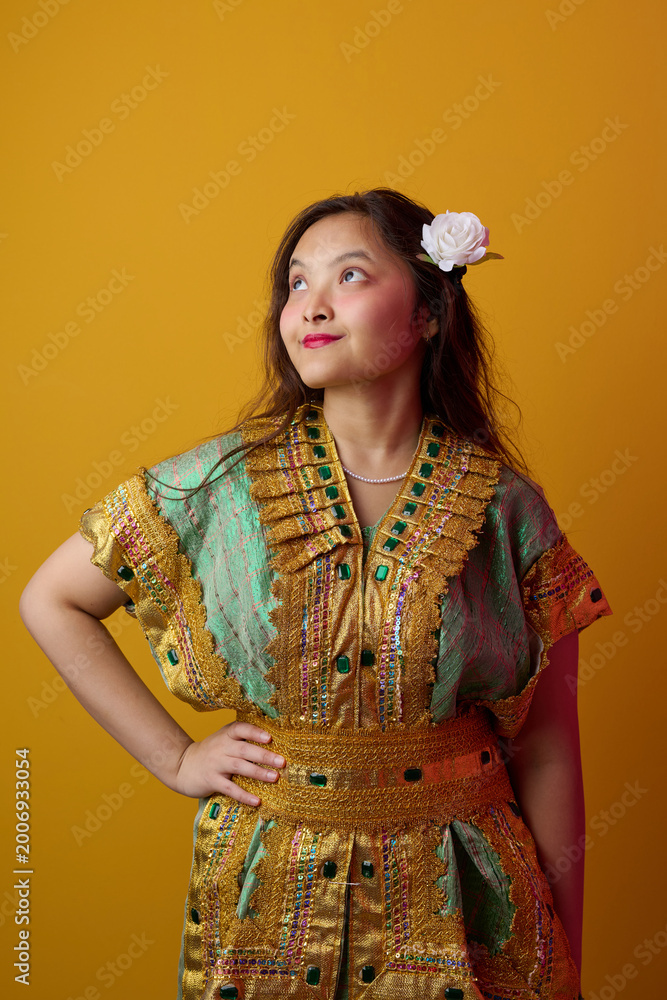 Fototapeta premium Young Indonesian Asian Woman in Gold Embroidered Traditional Dress With White Flower in Hair Portrait