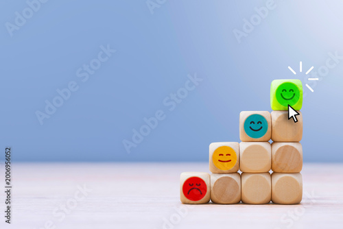 Pyramid of wooden cubes from red to green smiley face clicked by cursor. Concept for service quality, business success, customer experience and career growth. Dissatisfied to a happy face being.