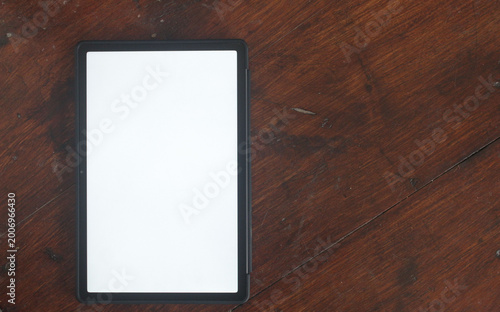 A tablet with a white screen and a wood grain background.