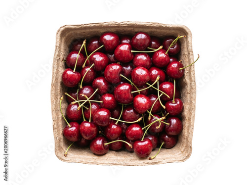 Quadro su tela Fresh ripe red cherries in a rustic cardboard punnet on a transparent background