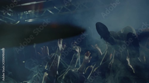 music crowd carrying crowd-surfer over raised hands, cheering, drumstick sweeping across cymbal