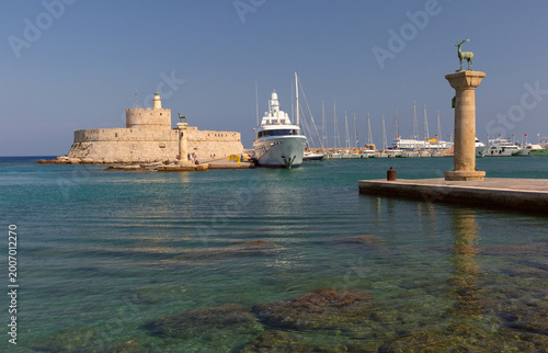 Mandraki harbor entrance with fortress and deer columns in Rhodes Greece