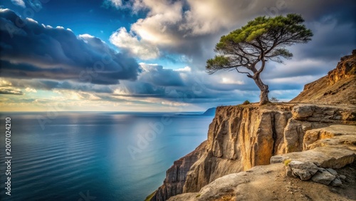 A solitary tree stands proudly on a dramatic cliff edge overlooking a vast ocean under a breathtaking sky