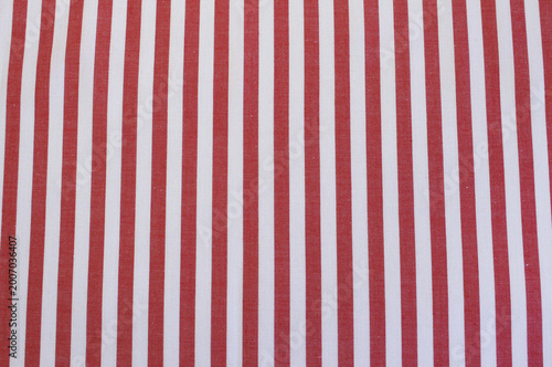 Close up of classic red and white vertical striped fabric. Texture of red striped cotton cloth background.