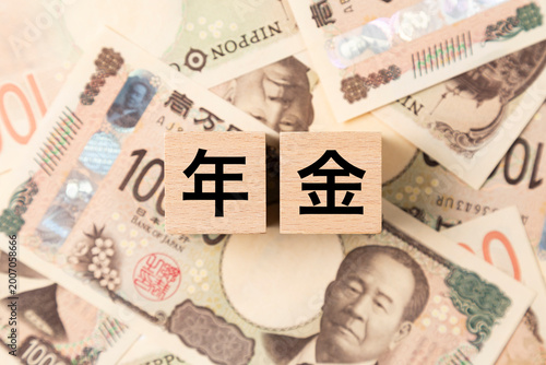 「年金」と書かれたブロックとたくさんの一万円札