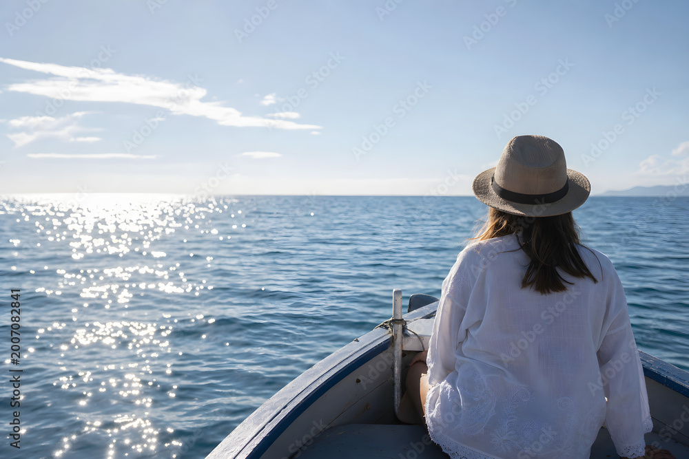 Fototapeta premium Traveler sitting on a boat facing the open sea