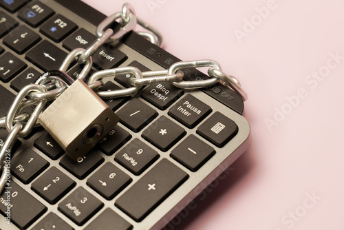Digital keyboard secured with a padlock and metal chain, symbolizing cybersecurity, data protection, and restricted access