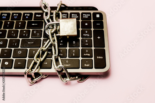 Keyboard representing online security and digital privacy, secured by a metal chain and padlock, protecting sensitive information