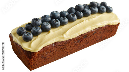A rectangular loaf cake topped with creamy yellow frosting and fresh blueberries on white surface