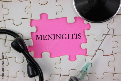 Meningitis highlighted on an pink puzzle piece surrounded by a stethoscope and syringe, conveying diagnosis, vaccination, medical care, public health awareness.