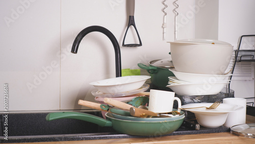 Kitchen sink overflowing with dirty dishes and pots