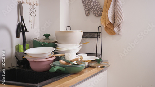 Pile of dirty dishes accumulating in kitchen sink