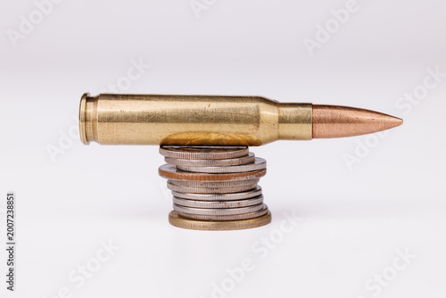 A single bullet and quarters on white. This scene illustrates the economic impact of the shooting industry and the price of security in the country.