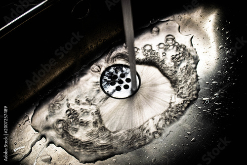 Fotografie Water Flow Into Sink Drain Captured With Slow Shutter Speed