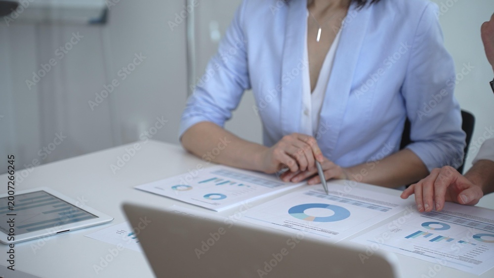 Fototapeta premium Business colleagues reviewing financial charts and marketing data during an important strategy meeting, analyzing sales reports and performance analytics for growth