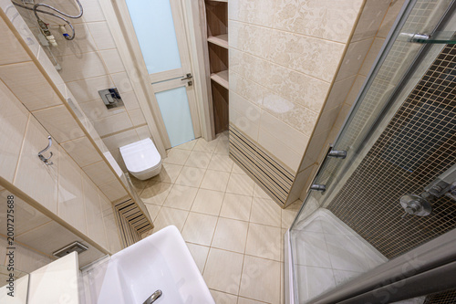 Quadro su tela light beige tiled bathroom with a glass-enclosed shower, wall-mounted sink, conc