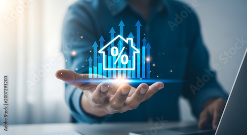 Hand holds glowing digital house icon with percentage and up arrows, depicting real estate investment growth, increasing property value, and rising mortgage rates