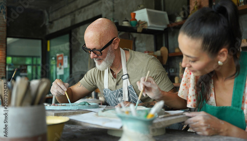 A happy couple makes ceramic plates in a workshop