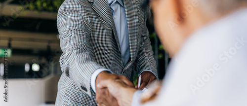 Фотография Professionals finalize contract through handshake in office environment