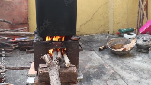 Raw 4K footage of water being heated on a wood fire for bathing, showing traditional method, simple living, and rural household routine in India.