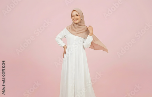 Portrait of a charming Muslim woman posing with hand under chin smiling at camera