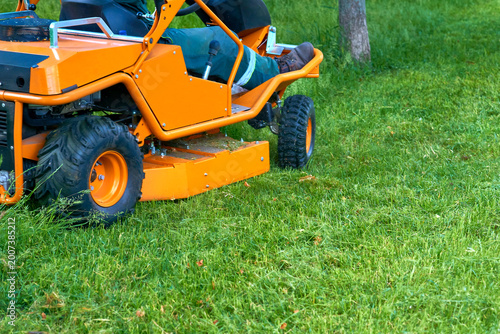 Professional grass cutting on lawns with a mini tractor lawn mower. 