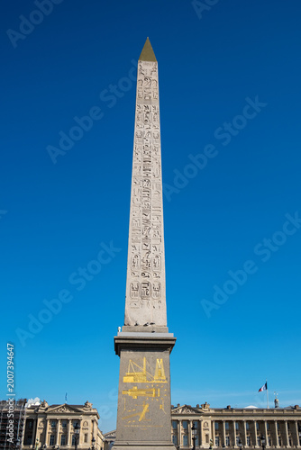 The ancient Egyptian Obelisk stands tall in the center of Place de la Concorde in Paris under a clear blue sky.