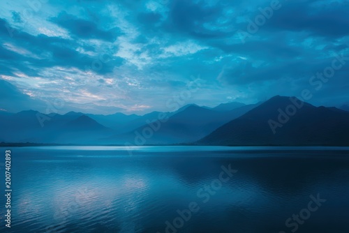 穏やかな山の湖水面に映る青い夕暮れ