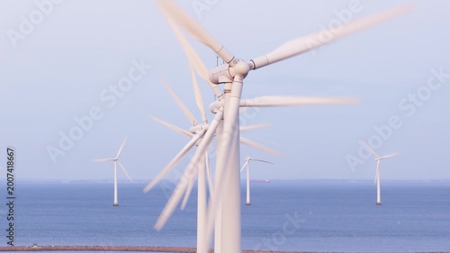 Wind turbines in motion, generating clean energy from sea, renewable power source, green technology.