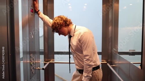 Tired office worker rides the elevator on the way to work showing morning fatigue low energy emotional strain and the quiet pressure of another demanding day
