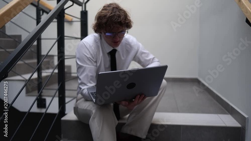 Deep in thought professional pausing on office stairs holding laptop reflecting on decisions quiet contemplation moment mental clarity problem evaluation focused introspection