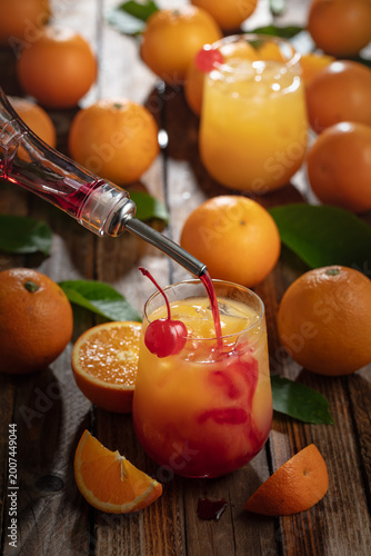 Canvastavla Classic tequila sunrise cocktail on an old wooden table.
