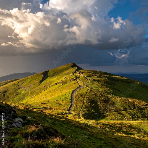Rolling green hills with a winding path under dramatic, cloud-filled skies