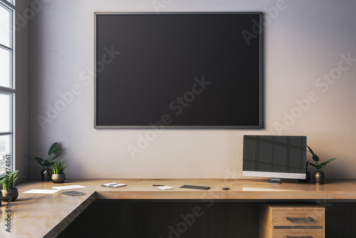 Clean office desk with large blank blackboard on wall in soft light creating modern workspace mockup scene for design and branding. 3D Rendering
