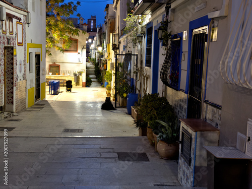 Illuminated Narrow Street in Mediterranean Coastal Town at Night