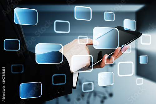 Business hand interacting with digital tablet interface surrounded by glowing...