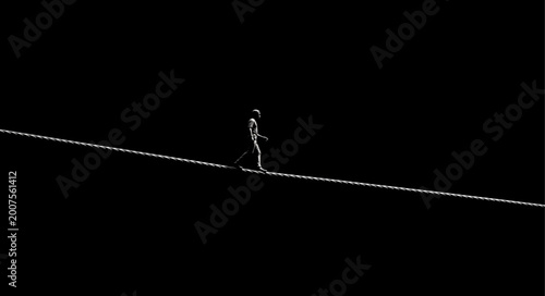 Photos Silhouette of a person walking on a tightrope in the dark.