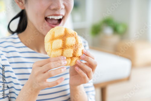 メロンパンを食べる若い女性
